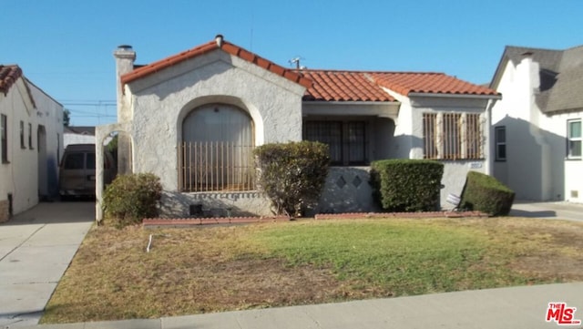 mediterranean / spanish house featuring a front lawn