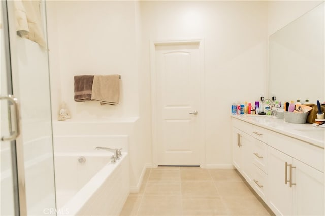 bathroom with a relaxing tiled tub, tile patterned flooring, and vanity