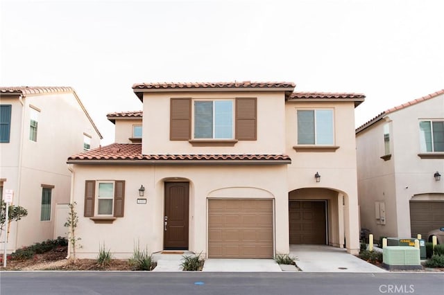 mediterranean / spanish-style home featuring a garage and central AC unit