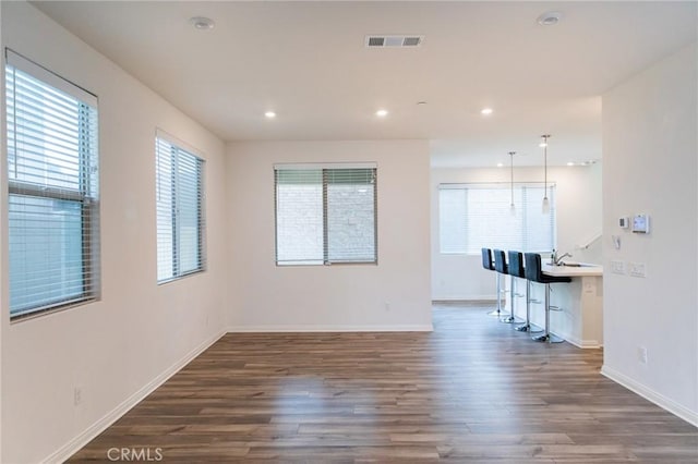 interior space featuring plenty of natural light and dark hardwood / wood-style floors