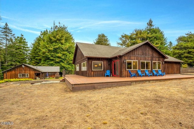 rear view of property featuring board and batten siding and a wooden deck