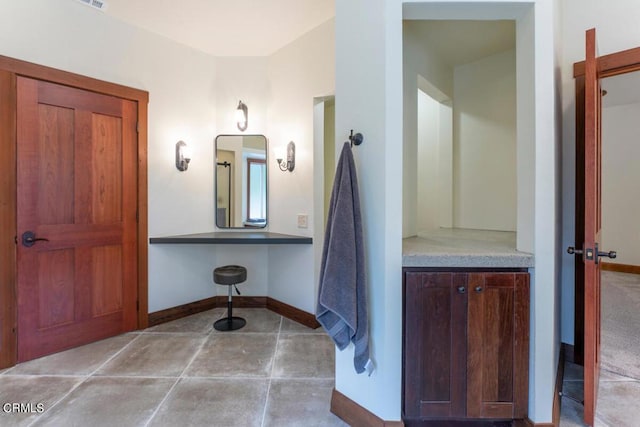 bathroom featuring tile patterned flooring, baseboards, and vanity