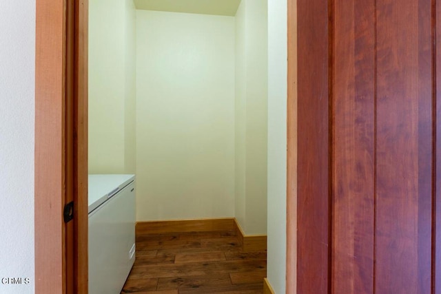 washroom featuring laundry area, baseboards, and dark wood-type flooring