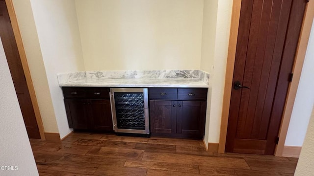 bar with wine cooler, dark wood-style flooring, baseboards, and a dry bar