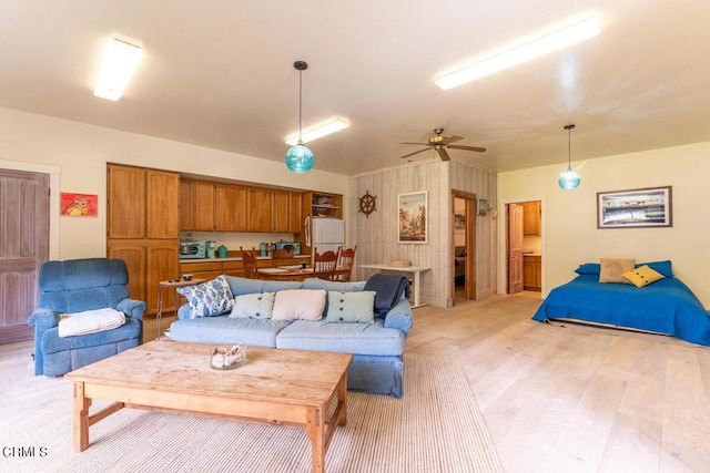 living area with ceiling fan and light wood-style flooring