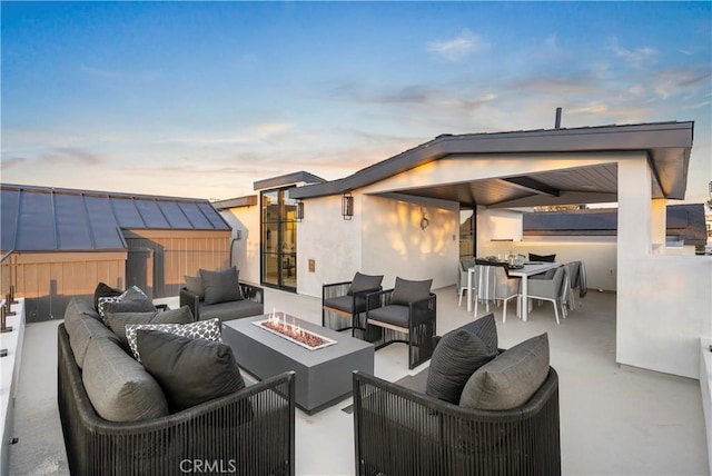 view of patio with an outdoor living space with a fire pit and outdoor dining area