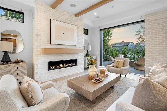 living room featuring wood finished floors, beamed ceiling, recessed lighting, and a fireplace