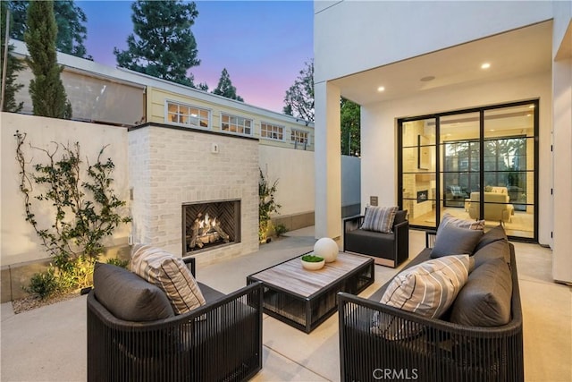 view of patio featuring fence and an outdoor living space with a fireplace