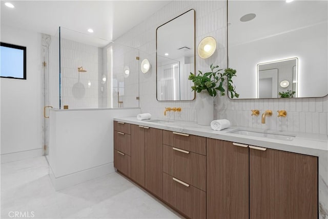 bathroom featuring a shower stall, backsplash, and a sink