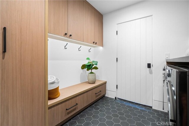 mudroom featuring dark tile patterned flooring and separate washer and dryer