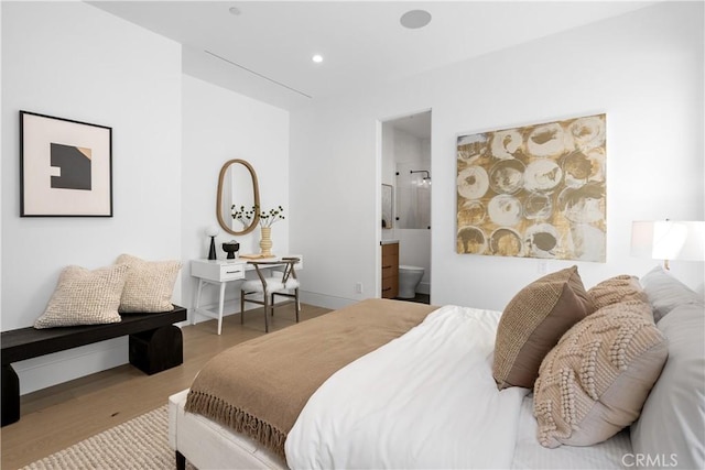 bedroom featuring recessed lighting, ensuite bathroom, baseboards, and wood finished floors