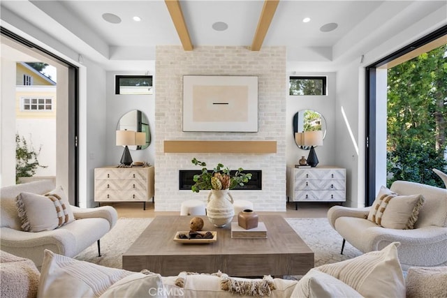 interior space featuring beamed ceiling, recessed lighting, a brick fireplace, and wood finished floors