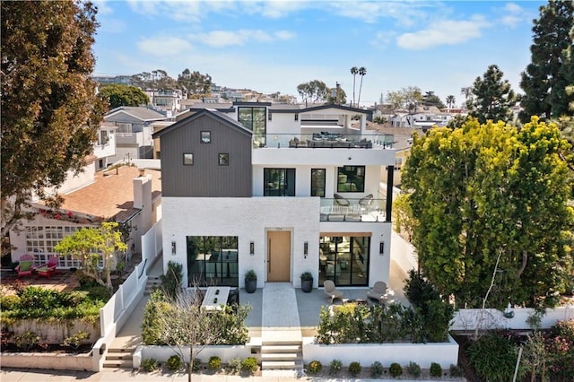 contemporary home featuring a balcony, fence, and a residential view