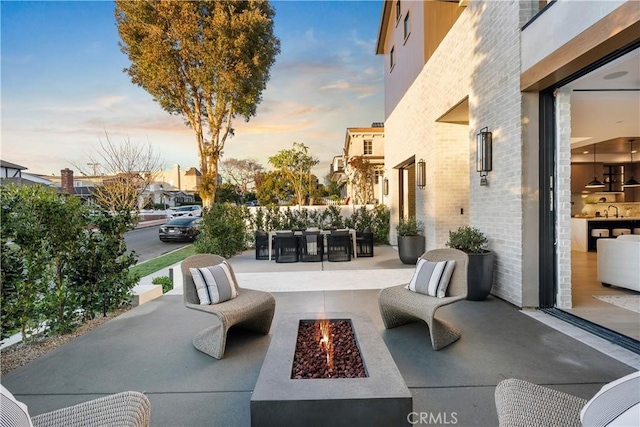 view of patio featuring a sink and an outdoor living space with a fire pit