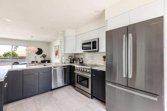 kitchen with white cabinets, sink, decorative backsplash, appliances with stainless steel finishes, and decorative light fixtures