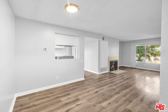 unfurnished living room featuring a textured ceiling and hardwood / wood-style floors