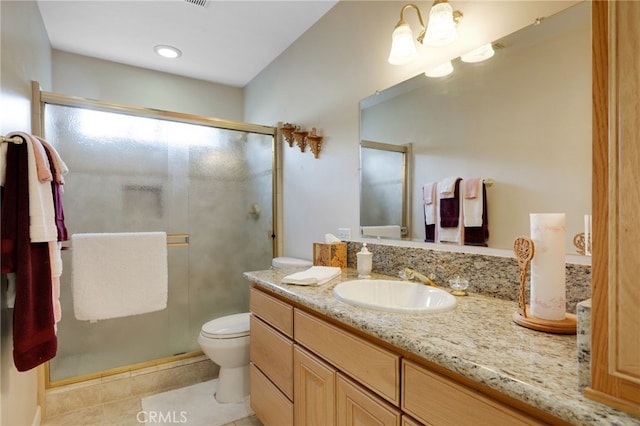 bathroom featuring tile patterned floors, a shower with door, vanity, and toilet