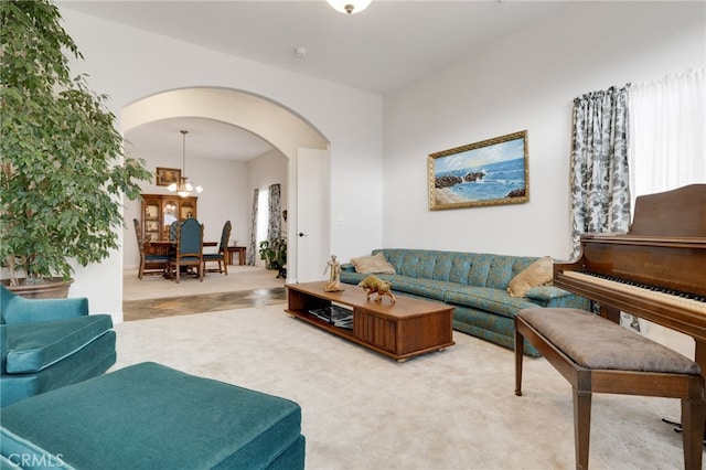 living room featuring carpet floors and an inviting chandelier