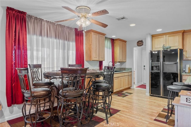 dining space featuring ceiling fan, sink, and light hardwood / wood-style floors