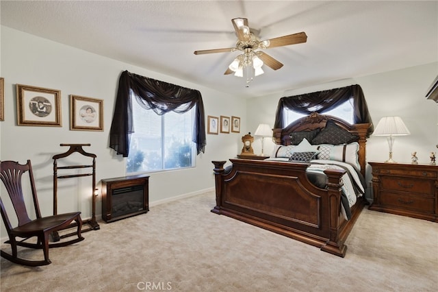 carpeted bedroom featuring multiple windows and ceiling fan