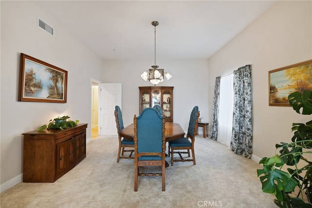 carpeted dining area featuring an inviting chandelier