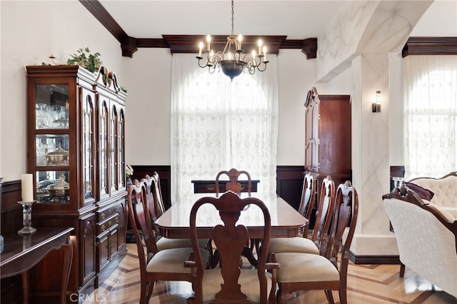 dining space featuring an inviting chandelier, ornamental molding, and a healthy amount of sunlight