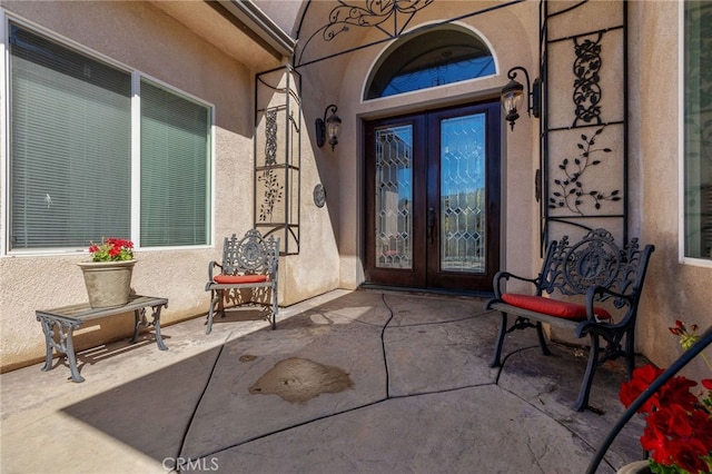 view of exterior entry featuring a patio and french doors