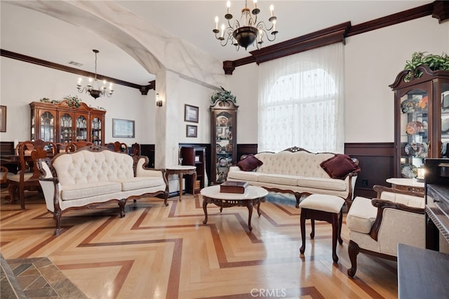 living room with light parquet floors, crown molding, and a chandelier