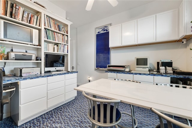 home office featuring built in desk and ceiling fan