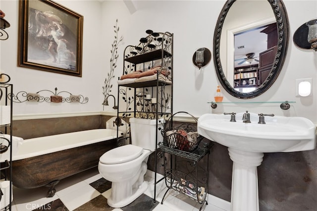 bathroom featuring tile patterned floors, a tub, and toilet