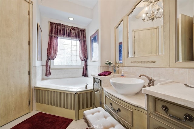 bathroom featuring a relaxing tiled tub, vanity, and a notable chandelier