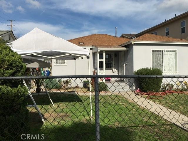 exterior space featuring stucco siding, fence, and a yard