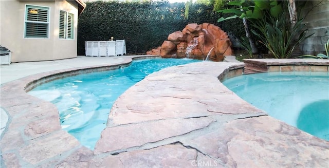 view of swimming pool with pool water feature