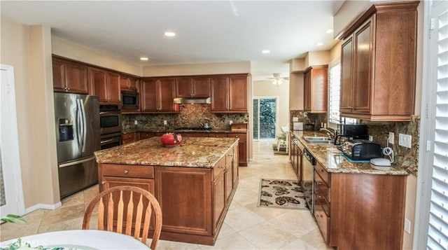 kitchen with decorative backsplash, a kitchen island, dark stone countertops, and appliances with stainless steel finishes