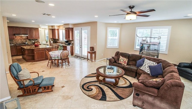 living room featuring ceiling fan, light tile patterned floors, and a wealth of natural light