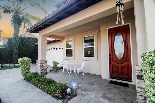 exterior entry at dusk featuring a garage