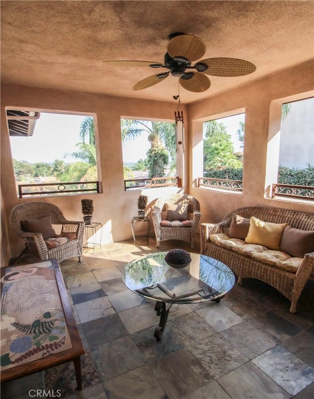 sunroom / solarium featuring ceiling fan