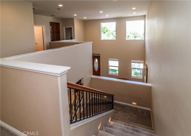 stairs with a wealth of natural light and carpet