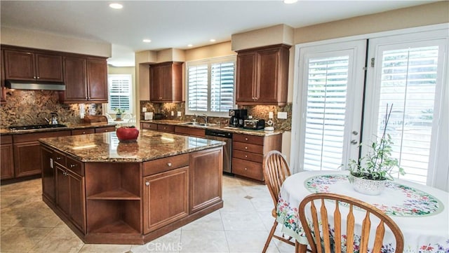 kitchen featuring a center island, a healthy amount of sunlight, appliances with stainless steel finishes, and dark stone counters