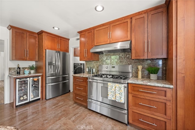 kitchen with light stone counters, wine cooler, stainless steel appliances, light wood-type flooring, and decorative backsplash