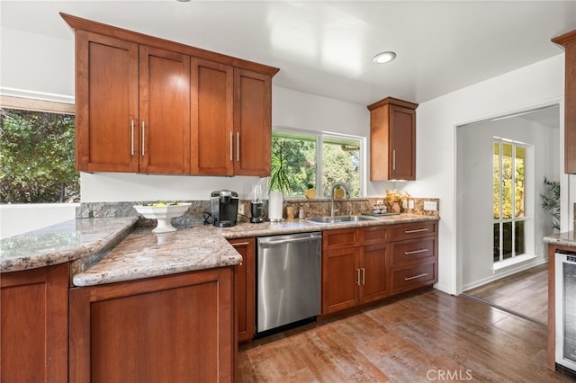 kitchen featuring light stone countertops, light hardwood / wood-style floors, dishwasher, and sink