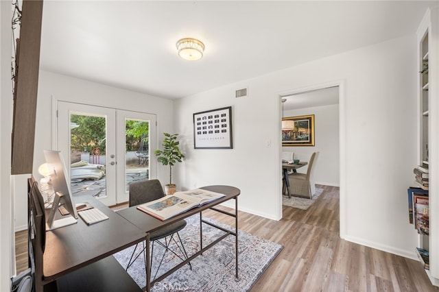 home office featuring french doors and light hardwood / wood-style floors