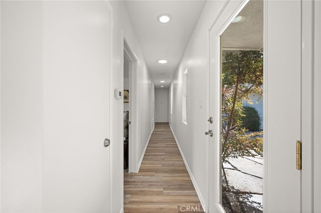 corridor with light hardwood / wood-style flooring