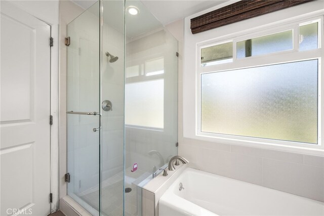 bathroom featuring separate shower and tub