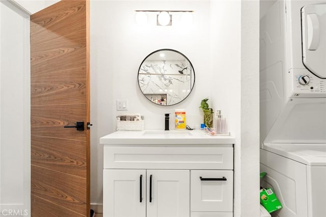 bathroom with vanity and stacked washer / drying machine