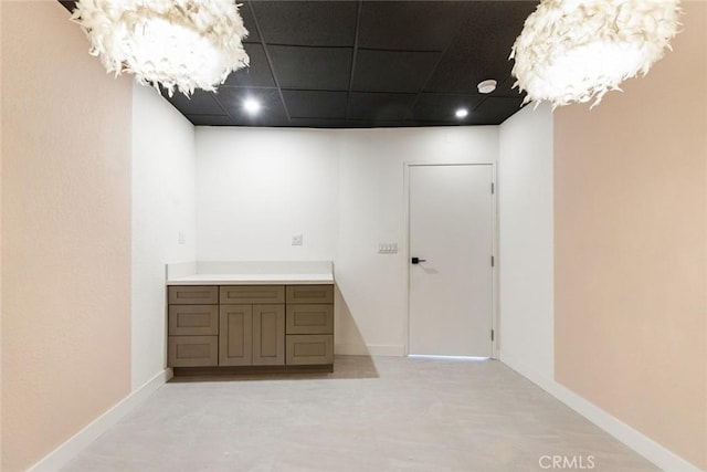 interior space featuring a drop ceiling and a chandelier