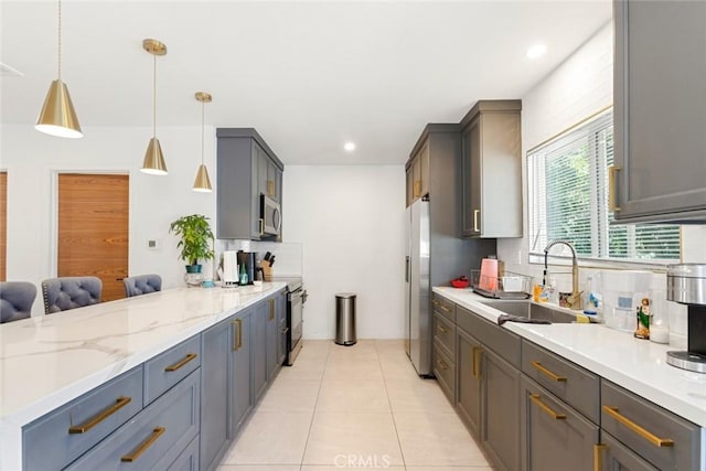 kitchen featuring appliances with stainless steel finishes, sink, gray cabinets, hanging light fixtures, and light tile patterned flooring