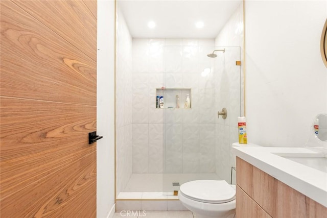 bathroom featuring tiled shower, vanity, and toilet