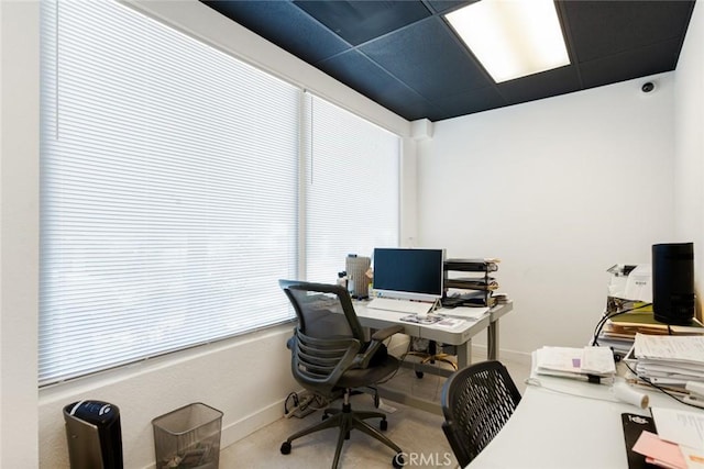 office space featuring a drop ceiling and plenty of natural light