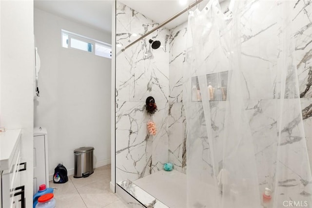 bathroom featuring a tile shower, tile patterned flooring, and vanity